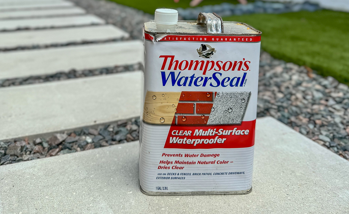 Close-up of a stone surface with water droplets beading up, demonstrating the effectiveness of a sealant in repelling moisture.